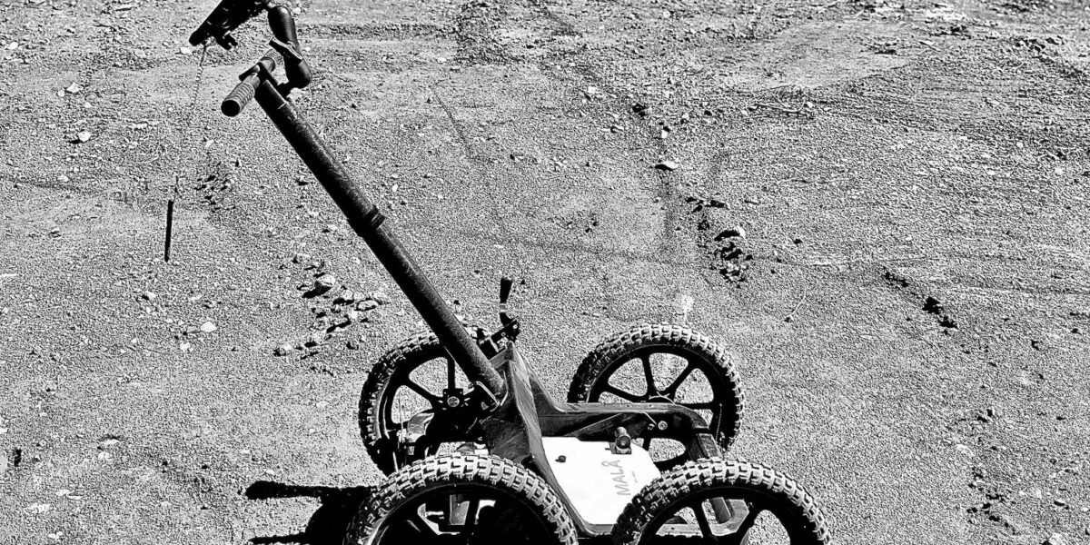 black & white subsurface radar equipment stationary on gravel