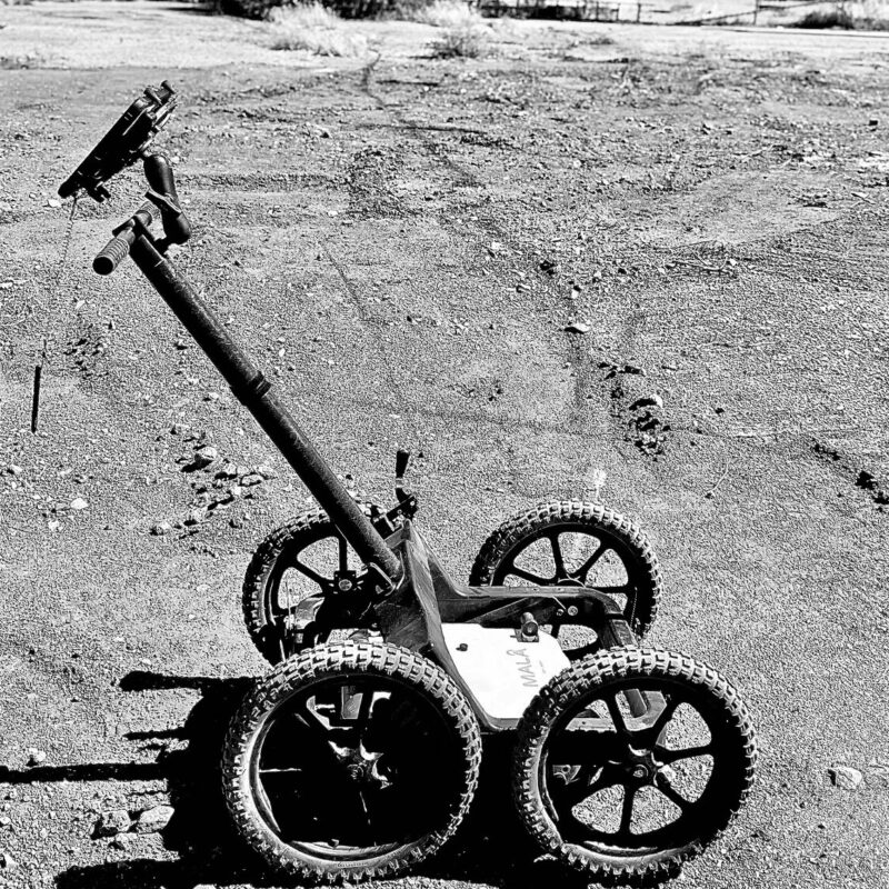 black & white subsurface radar equipment stationary on gravel